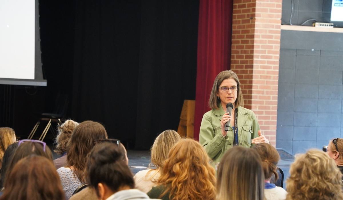 La directora interina de Eficacia Institucional, Jennifer Hadersberger, se dirige al personal docente y administrativo
