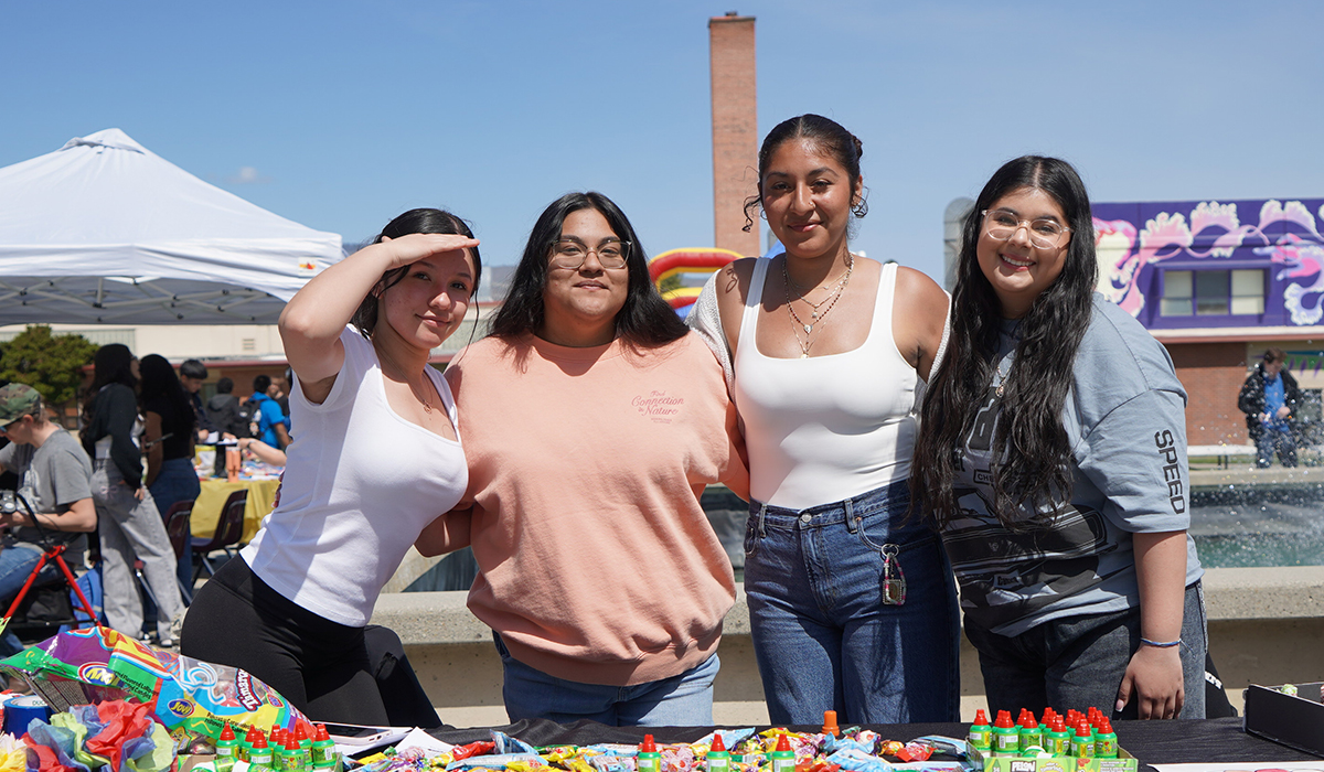 Tres chicas delante de una mesa junto a la fuente de WVC.