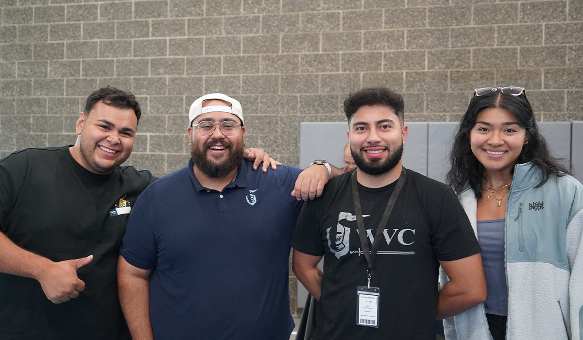 Cuatro miembros del personal de WVC posan juntos y sonríen a la cámara.