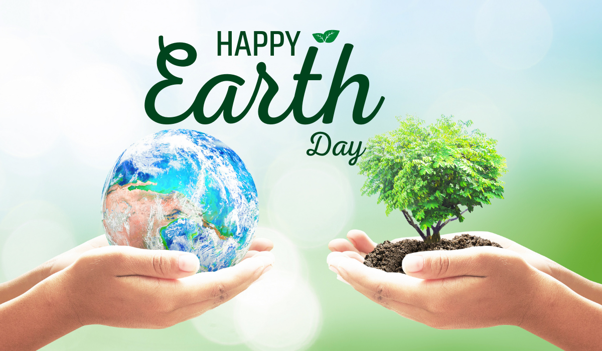 Una mano sostiene un globo terráqueo y la otra, un brote de planta en tierra