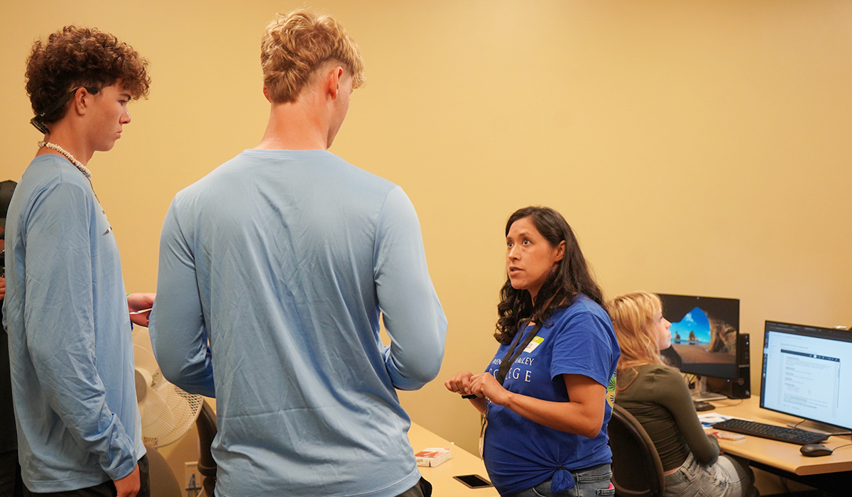 Un orientador universitario de WVC ayuda a dos estudiantes.