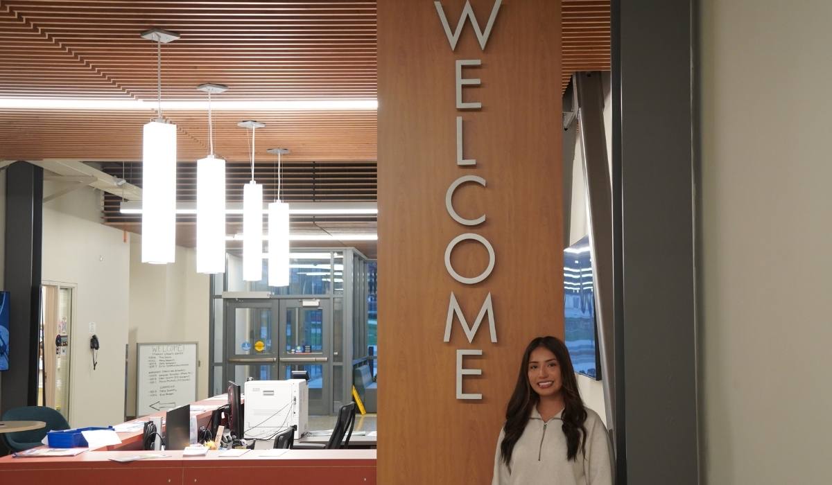 El orientador sobre prestaciones para estudiantes de WVC, frente al mostrador de bienvenida en Mish ee twie