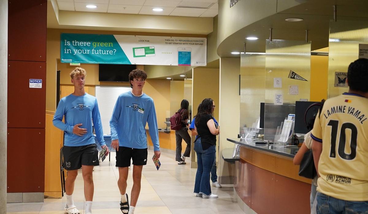Dos estudiantes pasando por delante de la oficina de ayudas económicas del WVC en Wenatchee