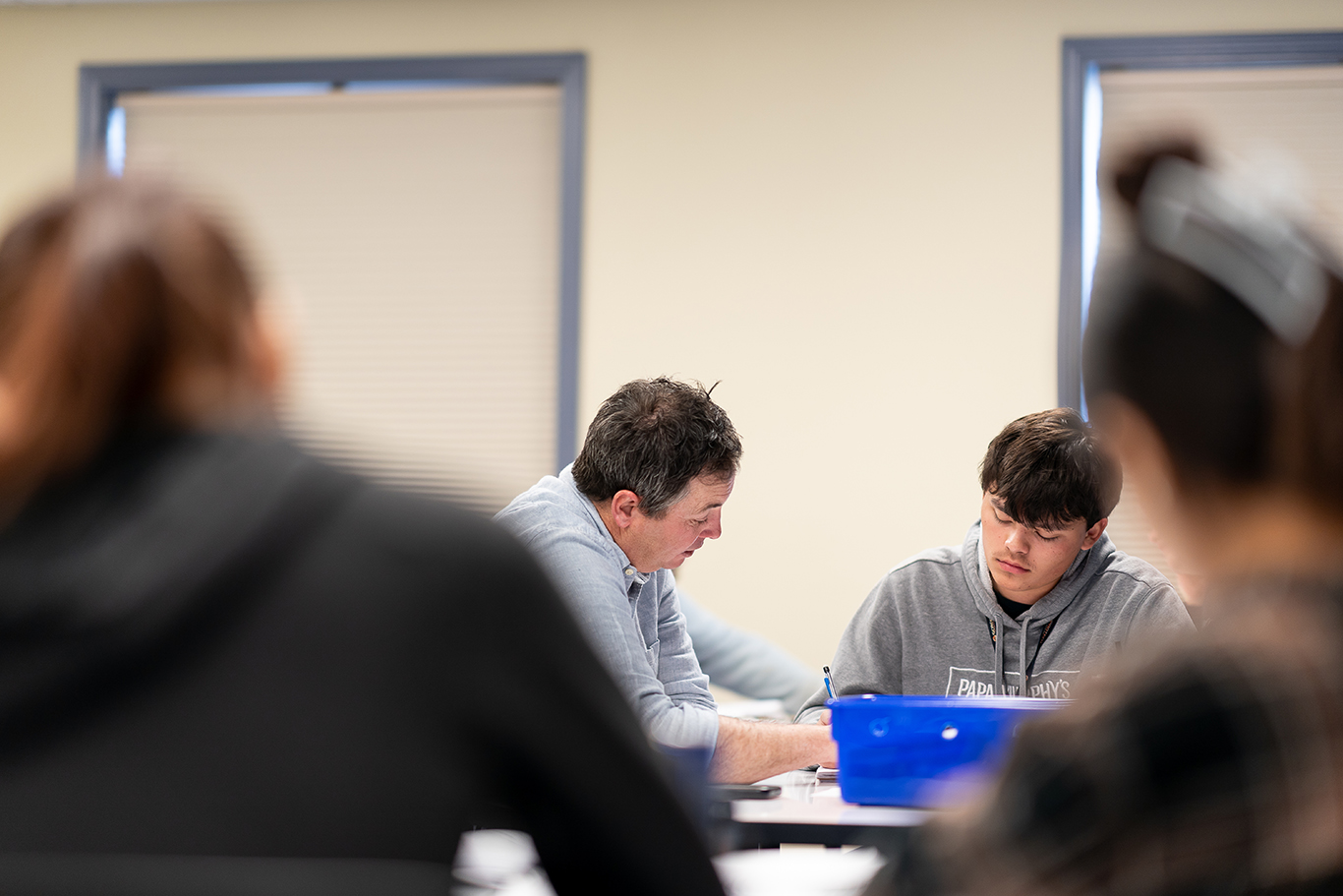 Profesor ayudando a un alumno en clase