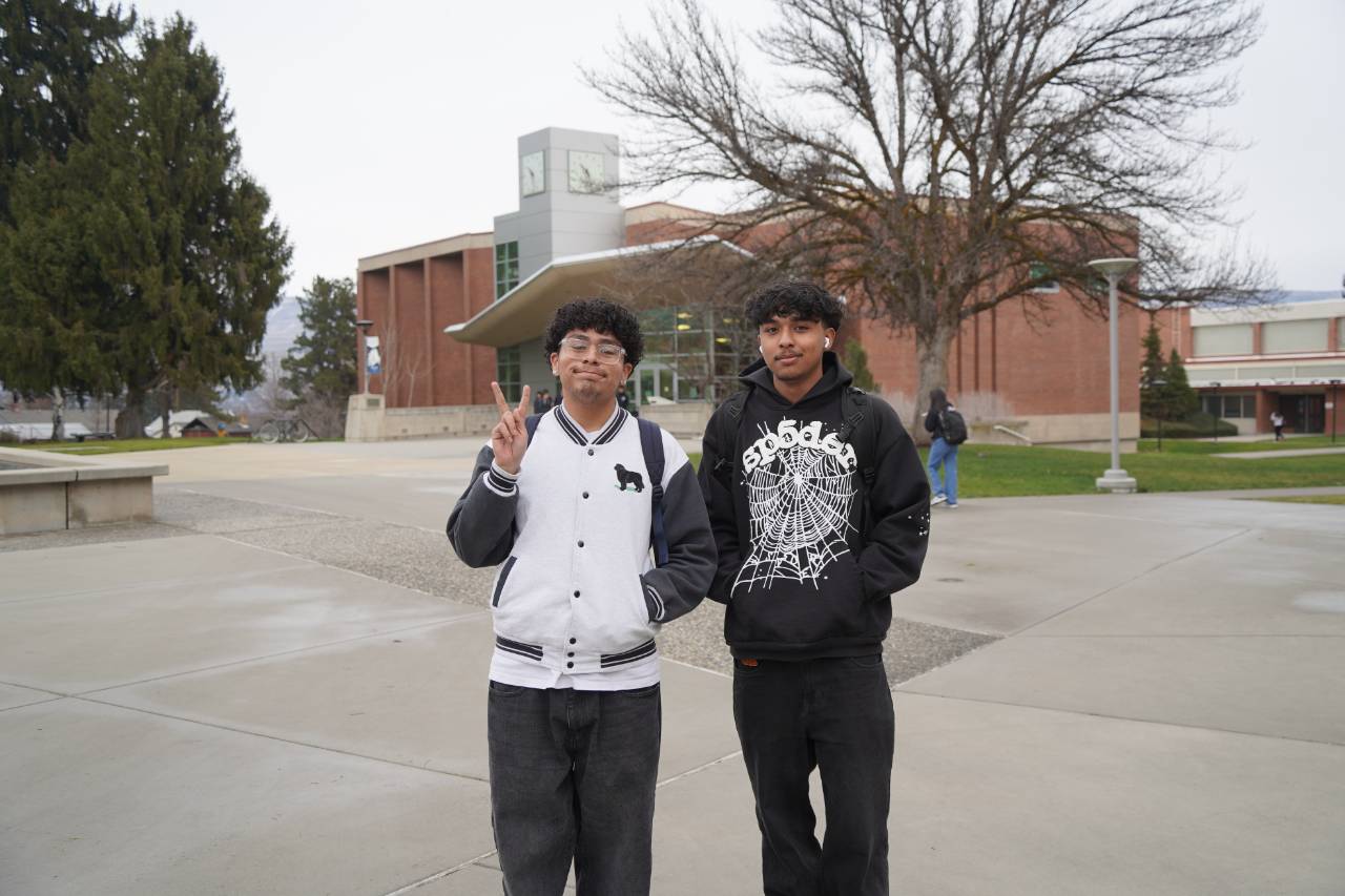 Dos estudiantes en el campus de Wenatchee, frente a la biblioteca Brown