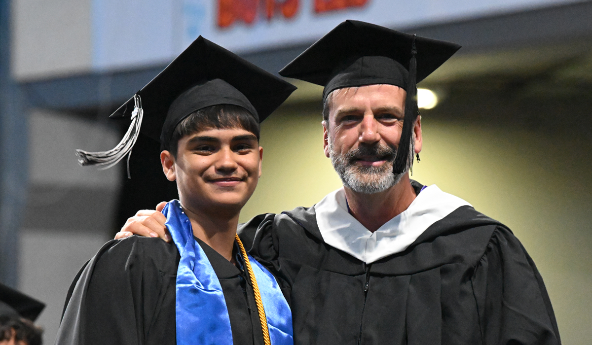El profesor de inglés Derek Sheffield, junto a un estudiante de posgrado, en la ceremonia de graduación de 2026.