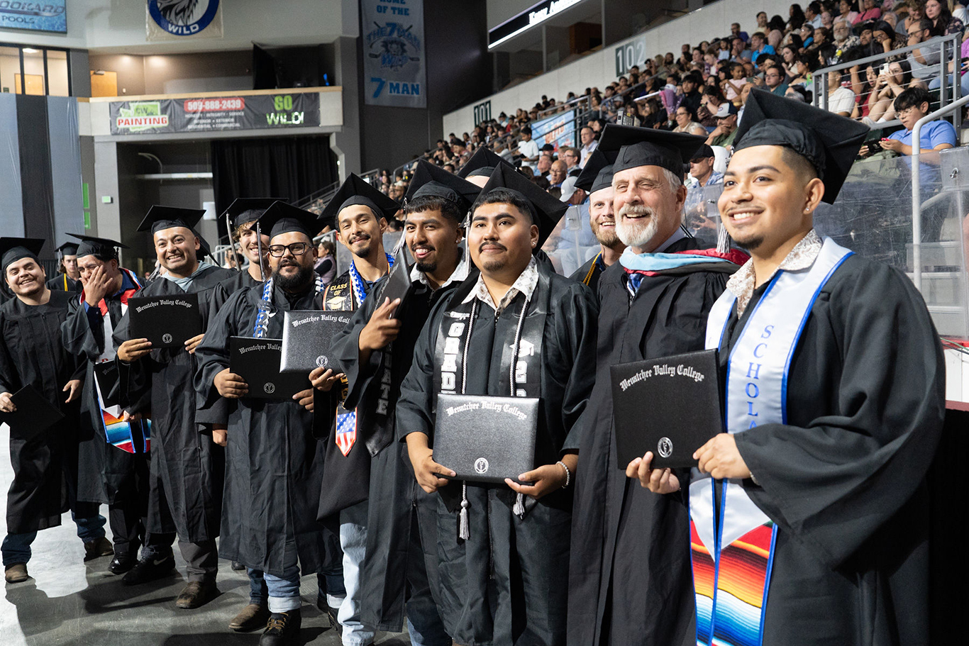 Estudiantes con el profesor Greg Jourdan en la ceremonia de graduación