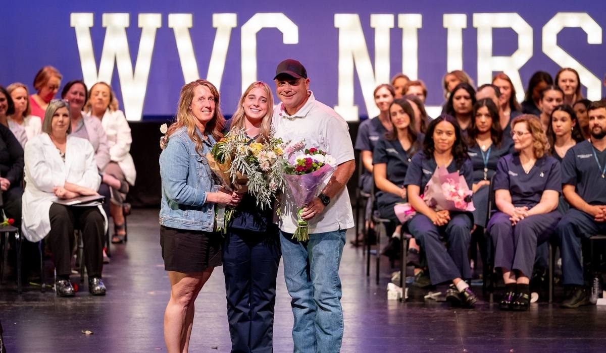 Una graduada en enfermería del WVC posa con sus familiares en la ceremonia de entrega de insignias