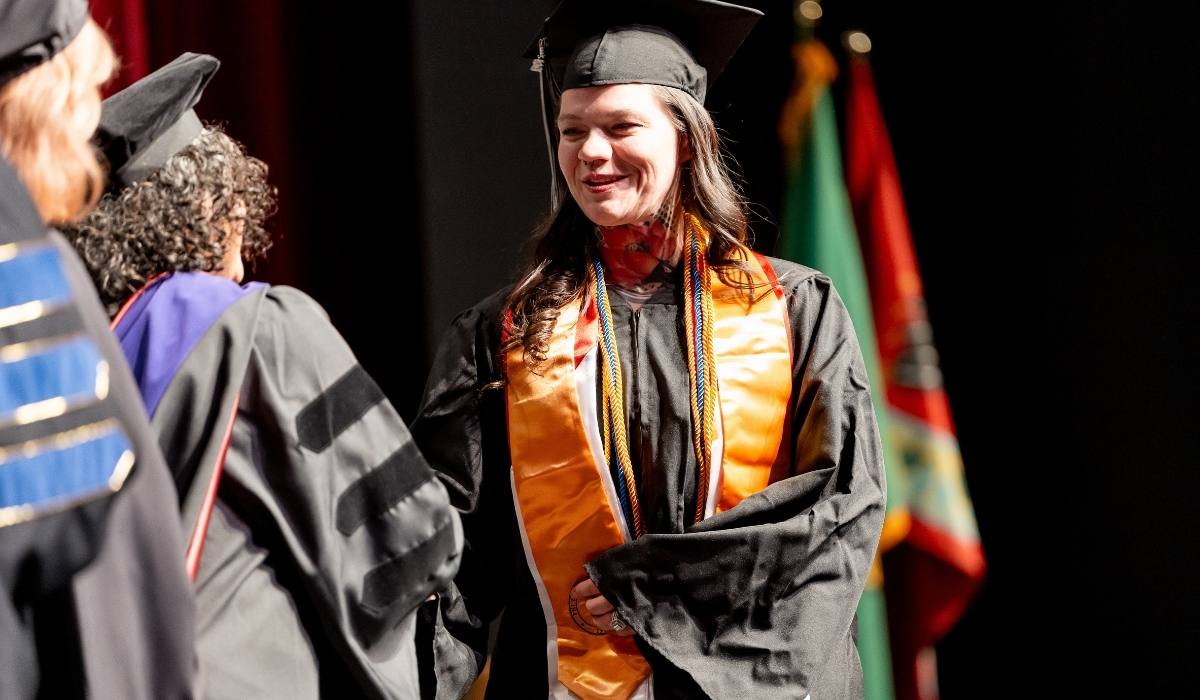 Un graduado de WVC Omak recibe su título de manos de un miembro del consejo de administración