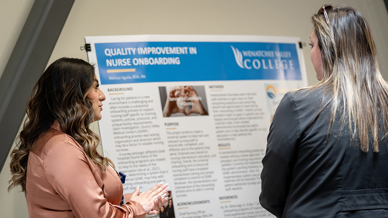 Una graduada en enfermería de la WVC habla con otra persona sobre su proyecto de investigación para pasar de enfermera titulada a licenciada en enfermería.