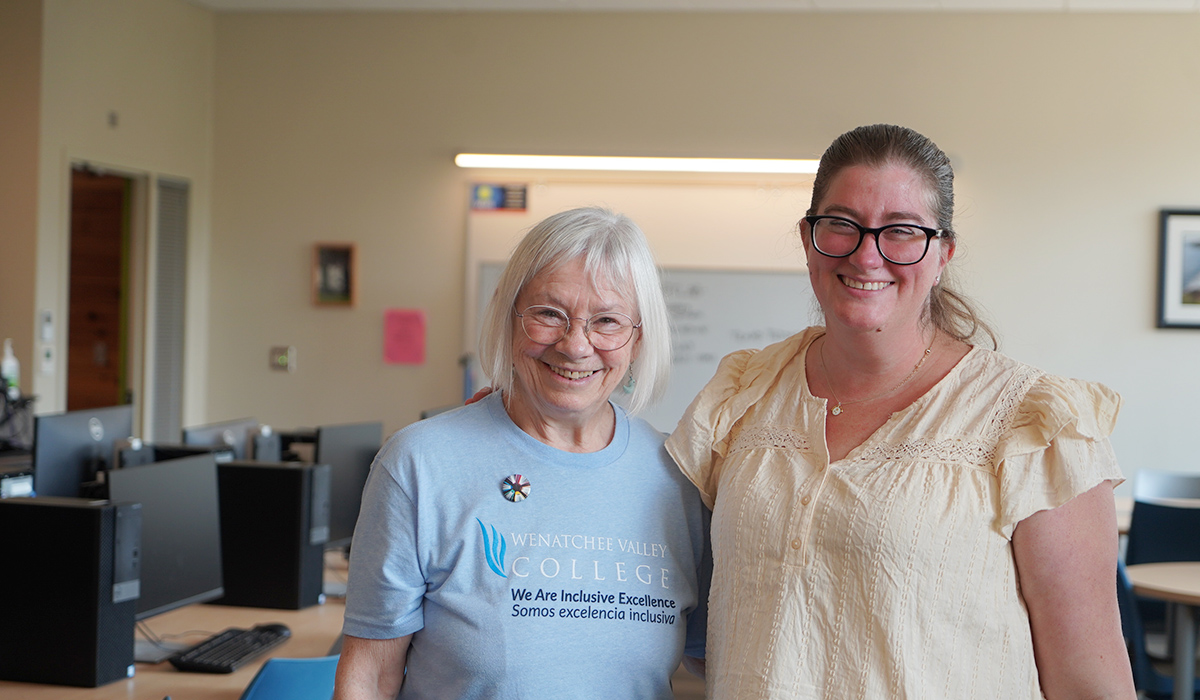 Dos alumnas del taller de escritura posan en el taller y sonríen a la cámara.