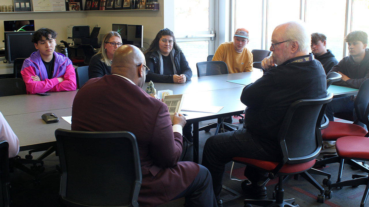 El rector de la universidad examina una tarjeta navideña que le ha enviado un estudiante de diseño gráfico.