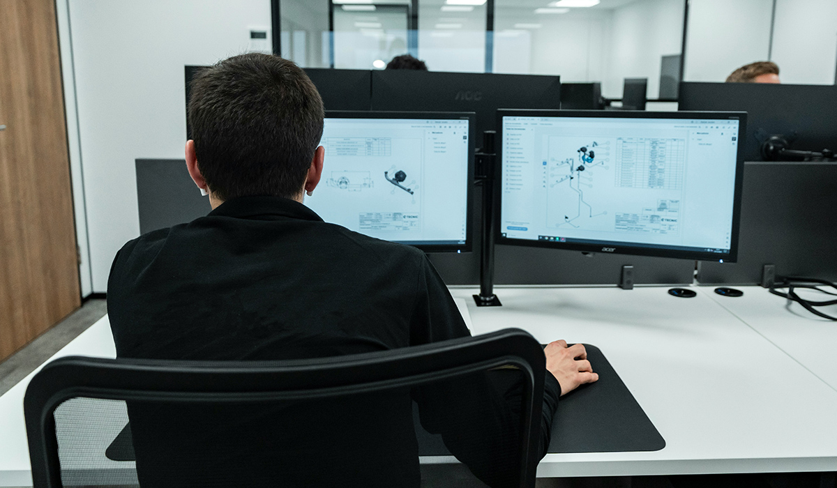 Una persona está sentada frente al ordenador trabajando en un diseño.