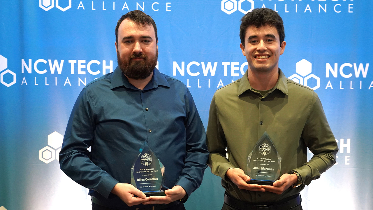Dos estudiantes de Ingeniería de WVC posan con sus premios de la NCW Tech Alliance frente a un fondo azul de la NCW Tech Alliance.