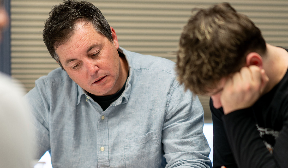 Un profesor de matemáticas ayuda a un alumno.