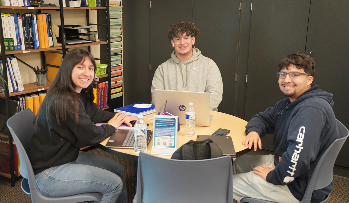 Tres estudiantes están sentados en una mesa en el Centro STEM de WVC.