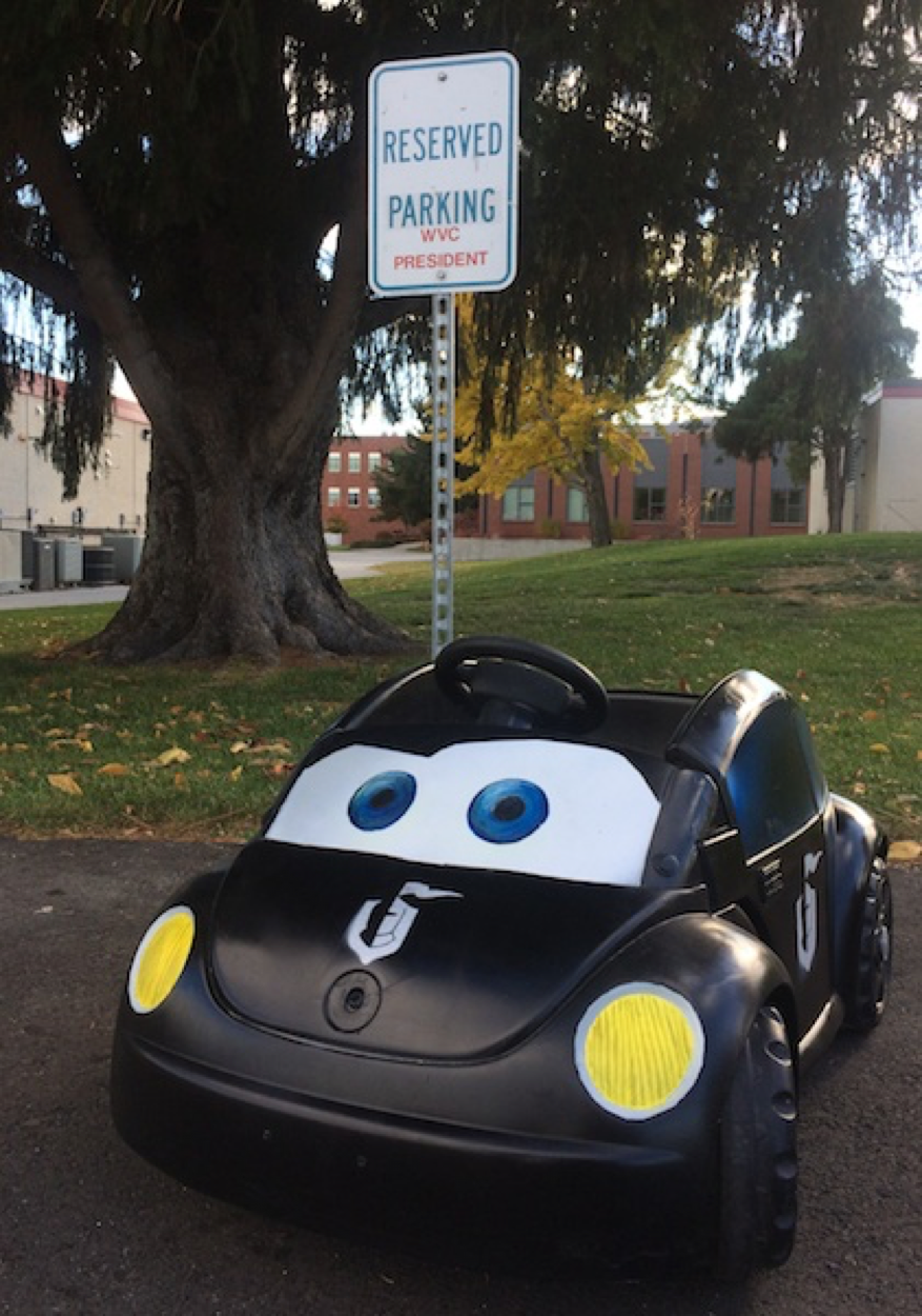 El coche Knight Bug está aparcado en un aparcamiento junto a un cartel de «Aparcamiento reservado».