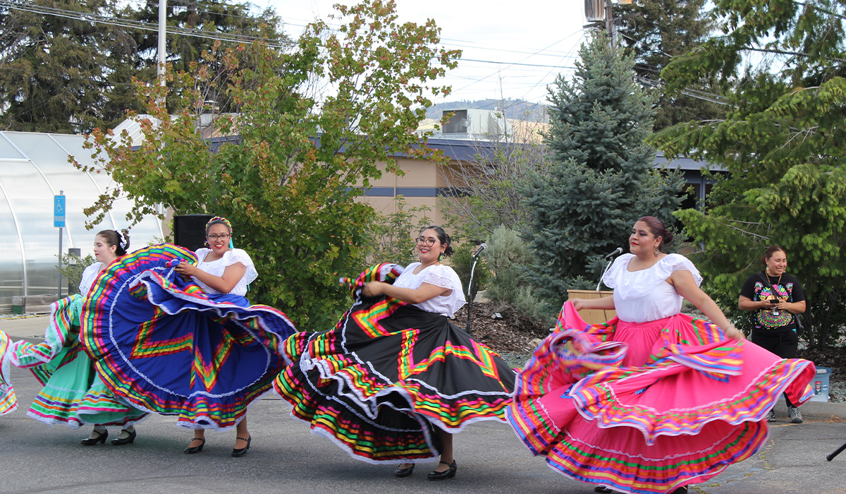 Unas mujeres vestidas con trajes tradicionales bailan al son de la música de mariachi.