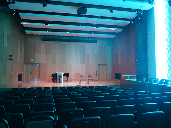 La sala de recitales The Grove, situada en el Centro de Música y Arte de WVC, se veía bañada por una luz azul procedente de las luces laterales de la sala.