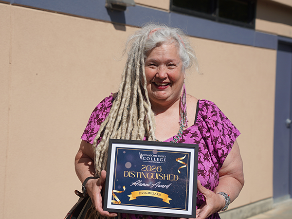 Livia Millard sostiene la placa del Premio al Antiguo Alumno Distinguido de la Fundación WVC.