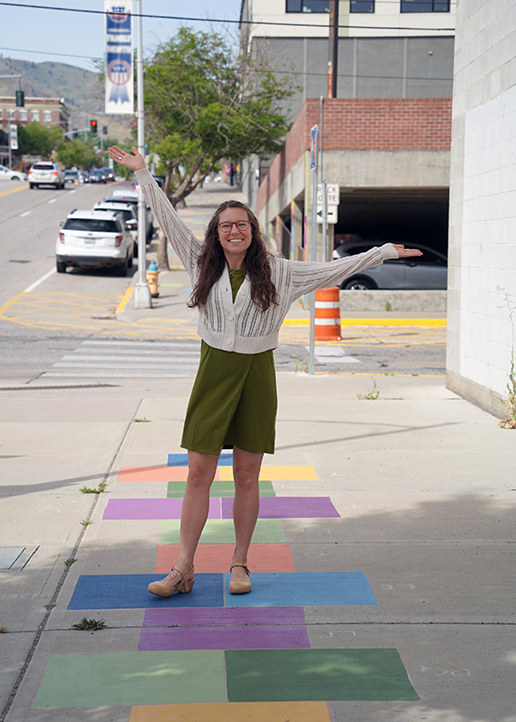 Ellen Bruex posa junto a un mural en la acera que ella misma ha creado.