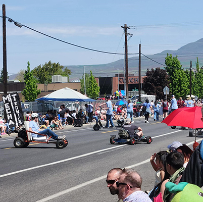 Los miembros del Club de Mecatrónica conducen sus karts por la carretera durante el Desfile de la Flor del Manzano.