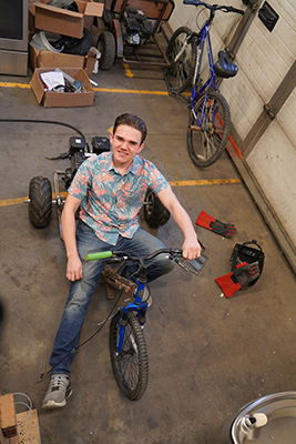 Cash Fowler está sentado en un kart en el taller de Tecnología Industrial.