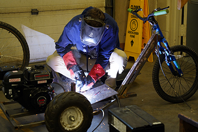Un estudiante del WVC realiza una soldadura en un kart.